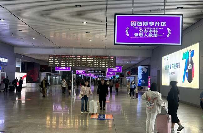 青島北站出站通道上方聯排大屏廣告出站客流人來人往 